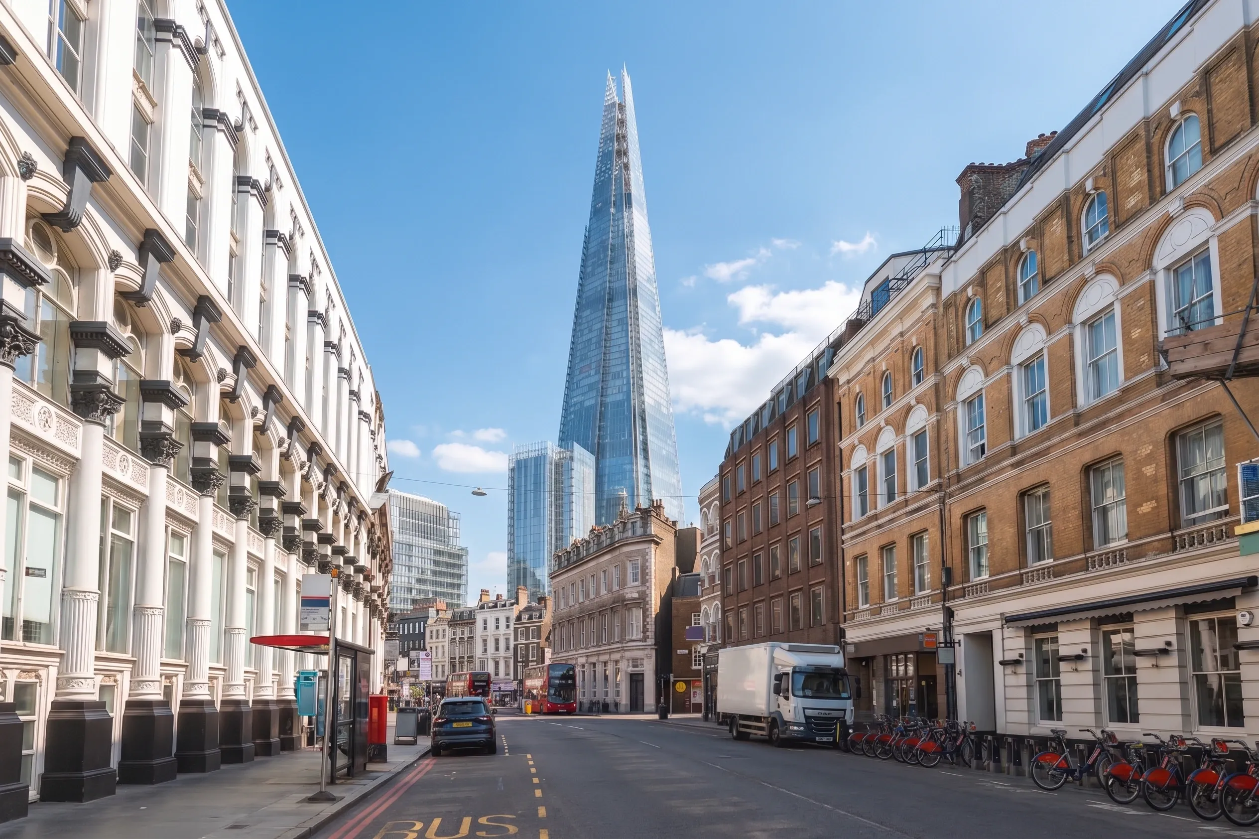 A street of Victorian and mid-century buildings in Southwark, with The Shard rising at the end of the road and a cycle docking station in the foreground.